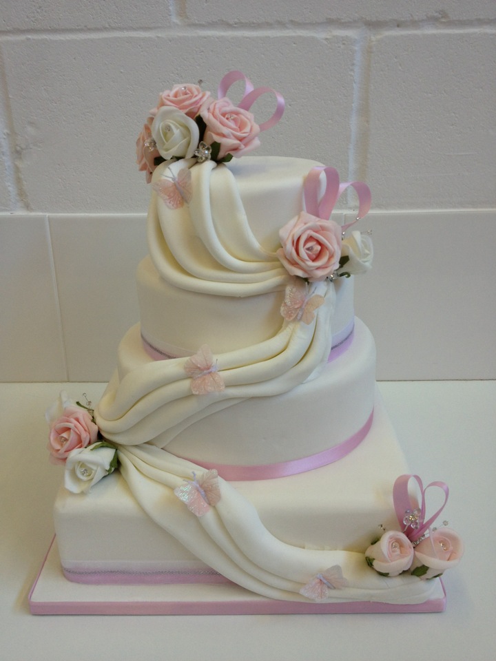 Pink and White Four Tier Wedding Cake with Roses and Swags