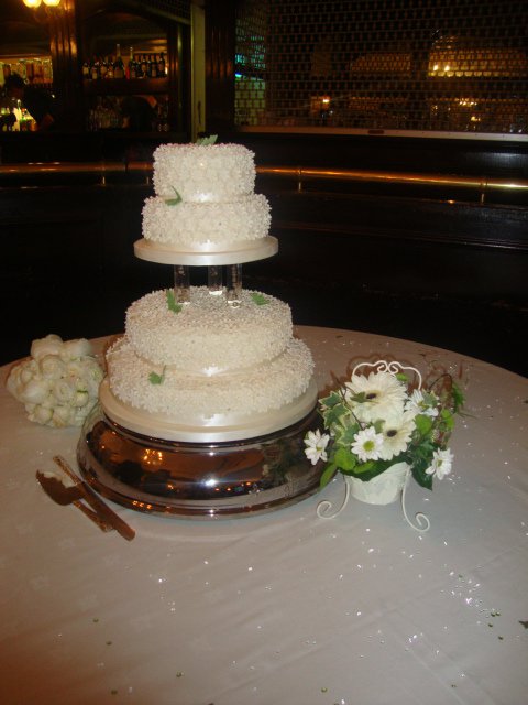 Four Tier Ivory Wedding Cake Covered in Daisies